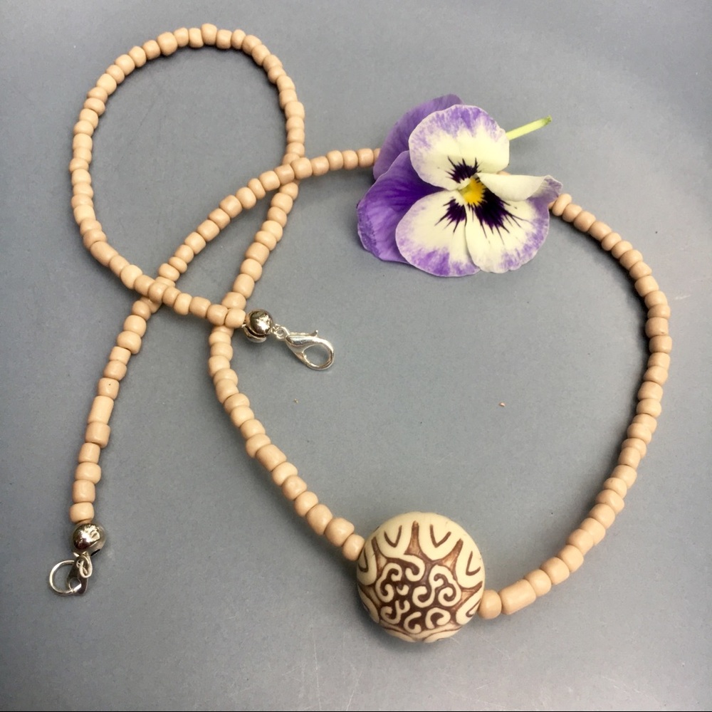 Stone carved pendant on glass beads
